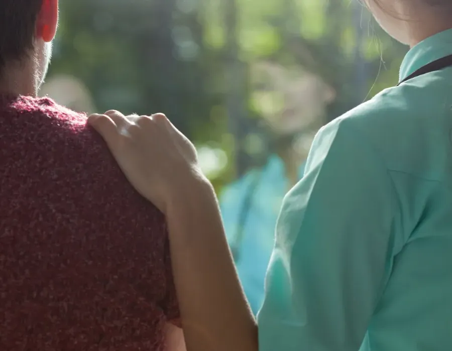 Psychiatric-Mental Health Nurse Practitioner PMHNP placing hand on patient's shoulder giving comfort